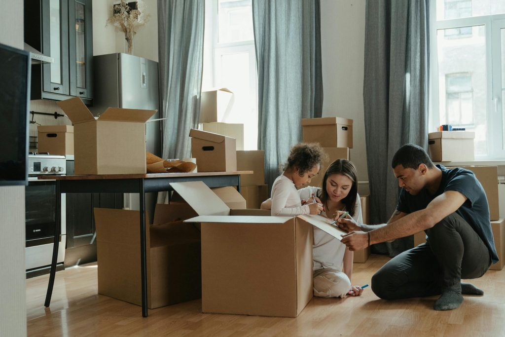 A family unpacks moving boxes in their new home kitchen, creating a cozy atmosphere.